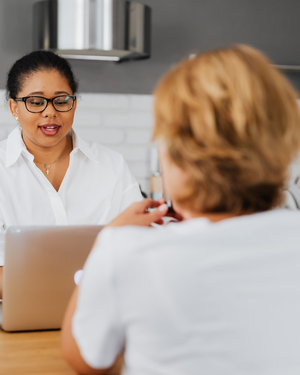 A support coordinator talking through options with a client at a kitchen table