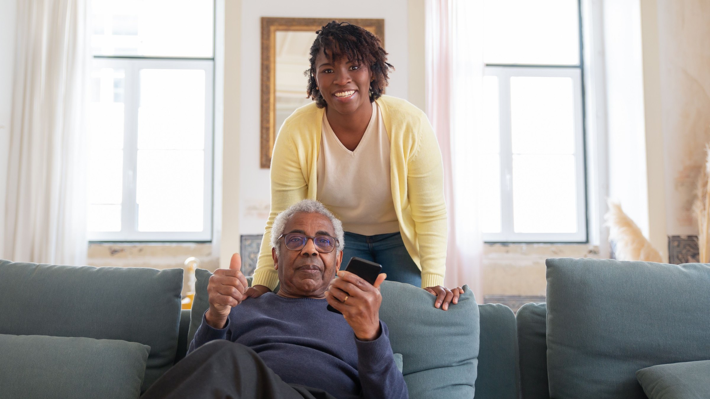 A caregiver and residents together in a warm, home-like living room